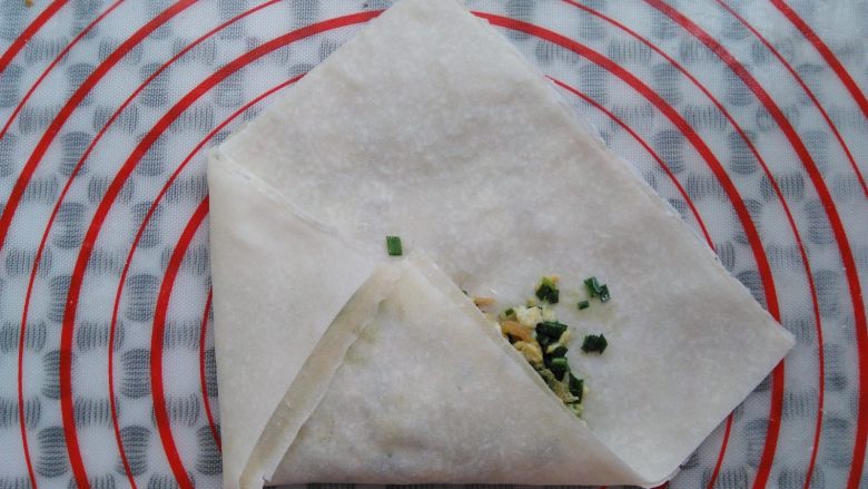 韭菜盒子(春卷版),春卷皮的左侧往右折,接口处可以抹一点水更好的沾合在一起