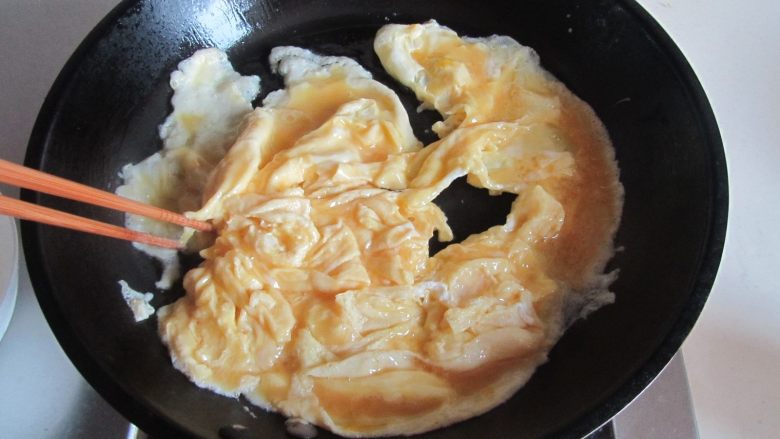 荷兰豆海鲜菇炒鸡蛋,热锅凉油,倒入打散的鸡蛋液,微微煎至定型用筷子划成小块, 盛出备用;