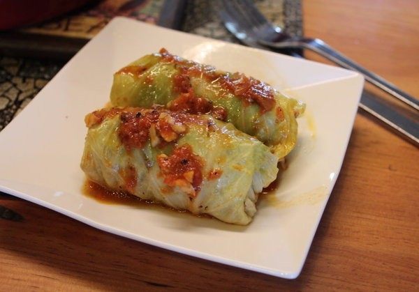 高丽菜牛肉卷,将高丽菜卷盛在盘上,淋上底部的酱汁。