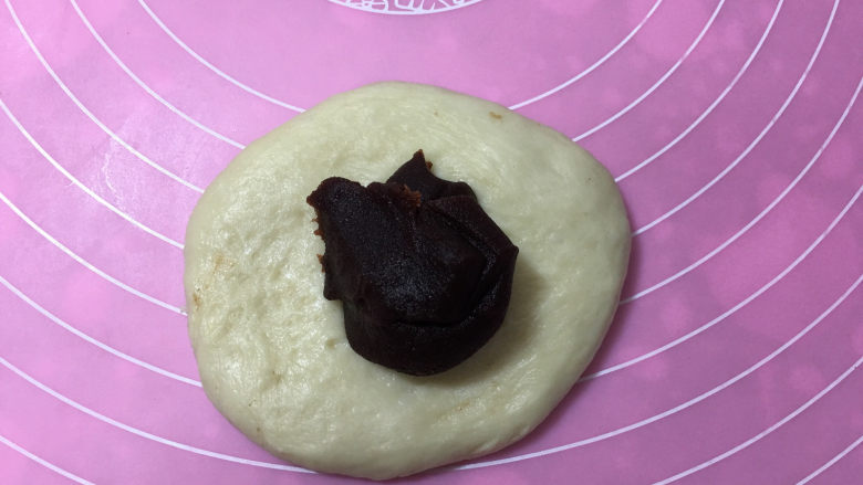 豆沙馅辫子面包(汤种法),醒面结束后,取一块面团擀圆,翻面放入<a style='color:red;display:inline-block;' href='/shicai/ 4729'>豆沙馅</a>。
