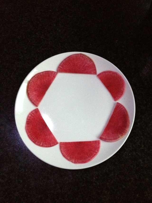 糖醋萝卜,先将萝卜片在盘里摆一圈,依次错开角度摆放第二层,三层