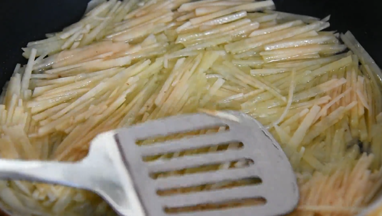大厨终于拿出绝招,麻香土豆饼,热油锅倒入土豆丝,用铲沿锅边压平土豆丝