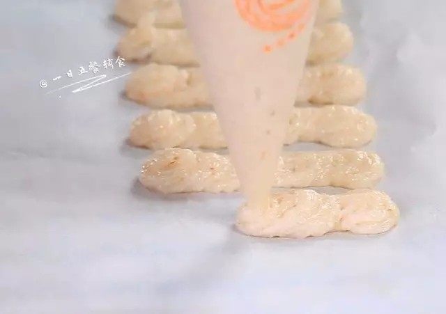 自制虾条,将裱花袋套在杯子上,虾糊放入裱花袋中,烤盘上铺一张烤纸,裱花袋剪个口,往烤纸上挤条状,粗细可以自己把握。