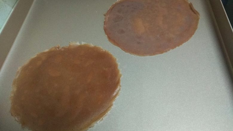 奥利奥可可千层蛋糕,把煎好的面皮放在烤盘里冷却,然后把饼皮一张一张的放在一起。(最好把饼皮放冰箱里冷藏1-2小时。)