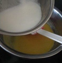 黄桃苏芙蕾乳酪蛋糕,煮沸的牛奶加进5的盆里快速搅拌,将盆放在沸水里面。用搅拌器快速搅拌蛋糊