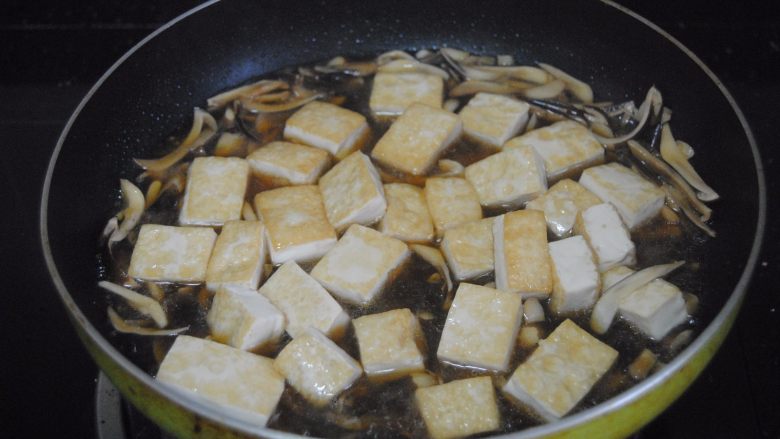 鸡枞菇烧豆腐,倒入豆腐焖煮1分钟,加入适量盐进行调味