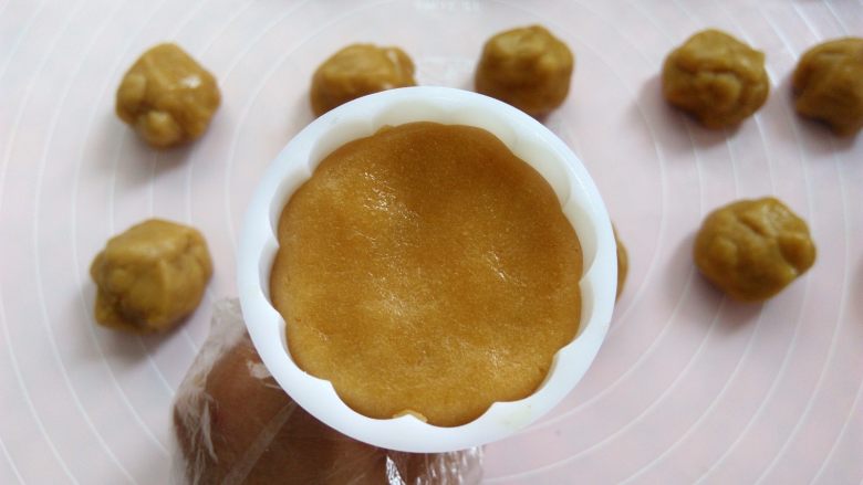椰蓉蔓越莓月饼,把月饼球放入50克模具里,可以按压一下模具边缘,压出来的花纹更立体