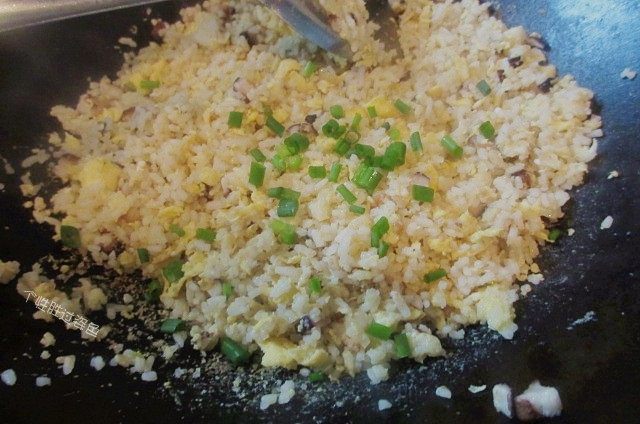 香葱炒饭,加入五香粉、盐。黑胡椒粉进行调味,出锅前撒上一把葱花提香