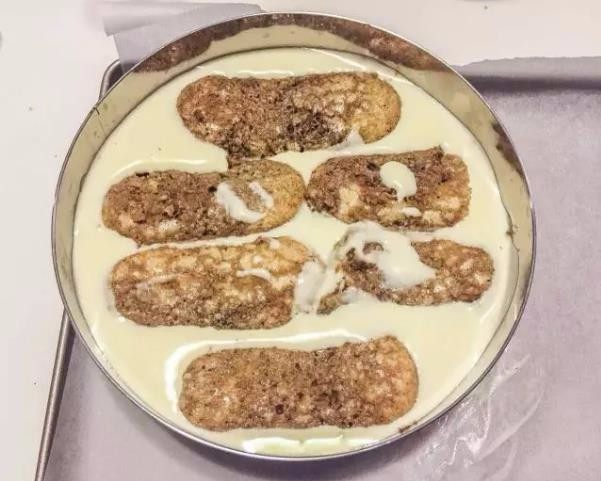 米其林私藏提拉米苏,把刷好咖啡糖浆的手指饼干放在提拉米苏面糊上。把剩下的提拉米苏面糊倒入慕斯圈，填满，顶部抹平，进冰箱冷冻4个小时以上。
