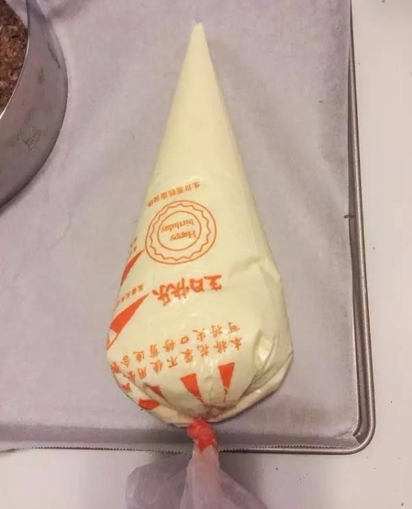 米其林私藏提拉米苏,用裱花袋装好提拉米苏面糊挤入慕斯圈至1/2处。
