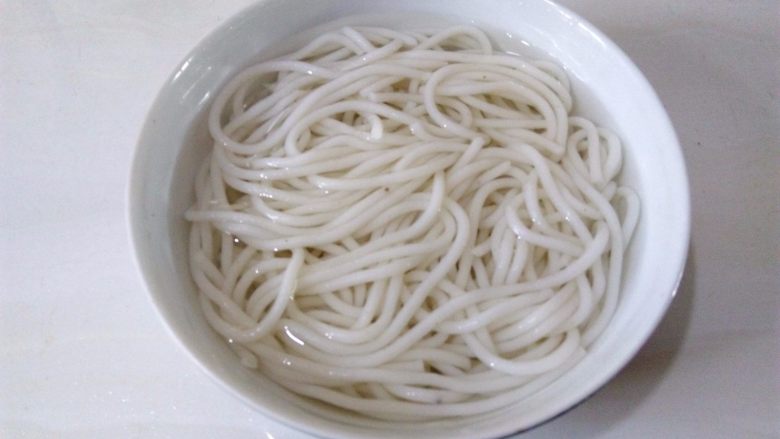 茄汁桂林米粉,取碗装温水,把米粉洗散,洗的过程中动作要轻一点,鲜榨米粉比较软,没有干米粉的韧性