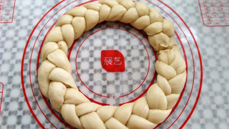圣诞花环面包,另外三根面条接到编好的面团后面,六根面条编成一个圆形,首尾接缝处捏紧(觉得麻烦的可以做2个小的花环)