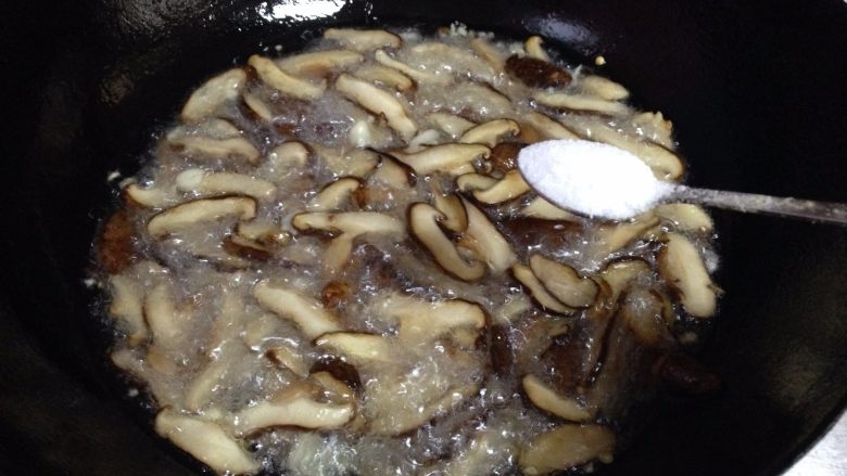 香菇菌子油,待香菇炸软出汁后放入适量的盐(约5克左右)继续炸
