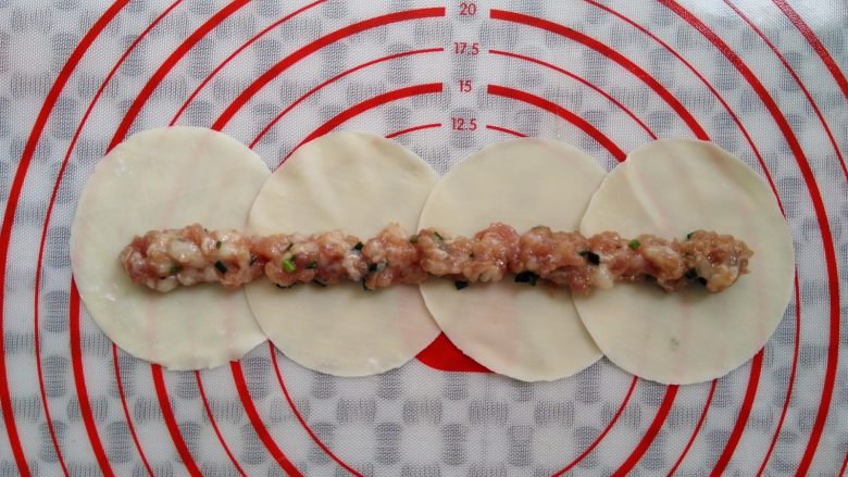 0技巧高颜值——玫瑰花饺子,在饺子皮的中间位置放上一长排的肉馅,不要放太多,多了后面比较难卷