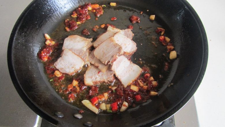 青椒素鸡炒回锅肉,翻炒出红油后加入卤肉进去煸炒;