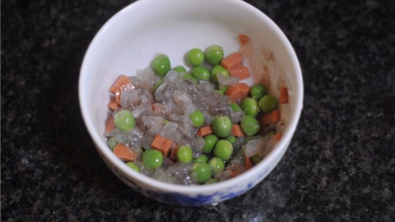 水晶虾饺,虾泥和胡萝卜丁、青豆粒混合起来,加入盐,拌成虾饺馅