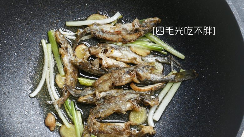 小黄甲鱼焖豆腐,热油，先下小黄甲鱼下锅小火煎，煎好一面后，下葱段和姜片，鱼煎至两面微焦和姜、葱段一起捞起备用；