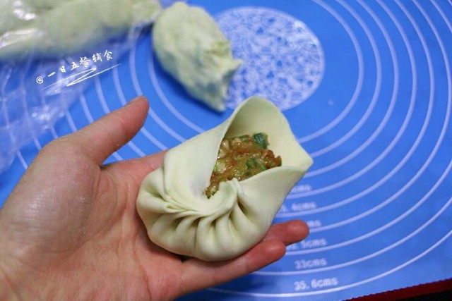 猪肉大葱包子,包成包子。将包好的包子放入垫了油纸的蒸笼里。在锅子倒入适量热水,放上蒸笼,盖上盖子,第二次发酵10-15分钟。