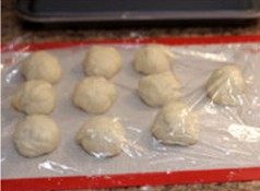 火腿花环面包 ,将面团放置温暖处,发酵1个小时至面包发至2倍大。用手指沾面粉,摁个点,不回弹,边上的面团不回缩即可。瘦身减气,分成均匀11份(约55g一个),搓圆中间发酵10分钟