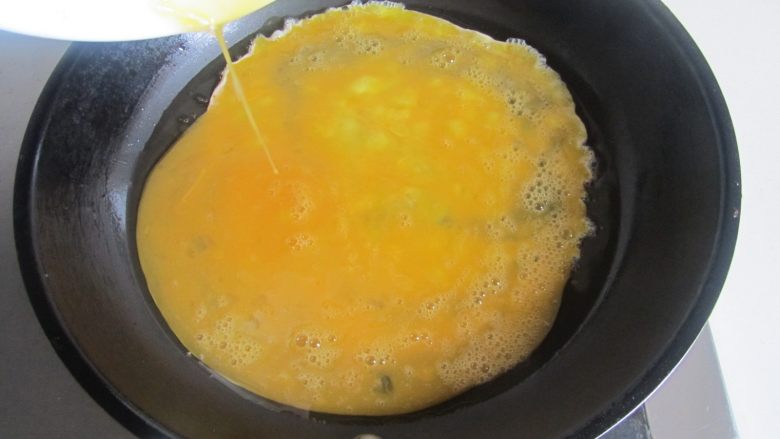 苦瓜炒鸡蛋,热锅凉油, 倒入鸡蛋液进去煎;