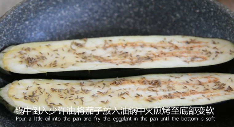这样做比烧烤摊上的蒜泥茄子好吃100倍,锅中倒入少许油,将茄子放入油锅,中火煎烤至底部变软