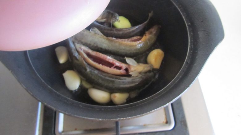 青豆泥鳅汤,记得马上要加盖哟,因为泥鳅会在里面翻动厉害,这样能防止油溅到身上;待听到里面完全无翻动的声音后就可揭开盖,