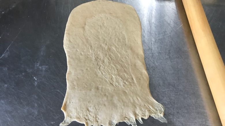 胚芽金枪鱼包,松弛好之后小面团放在案板上,用手掌按压扁平,擀呈长方形后翻面
