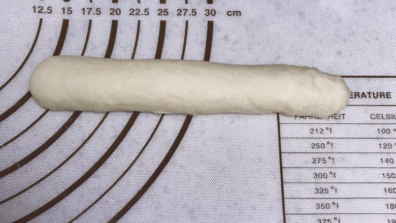 香葱芝士心形餐包,从一侧卷起,收紧收口。搓揉成25厘米左右的长条。