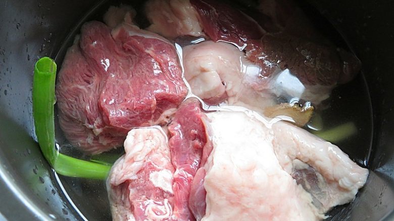 羊肉泡馓子,电饭煲内铺上葱段、姜片,放入羊肉和没过羊肉的水,设置羊肉键炖30分钟,不要炖的太烂