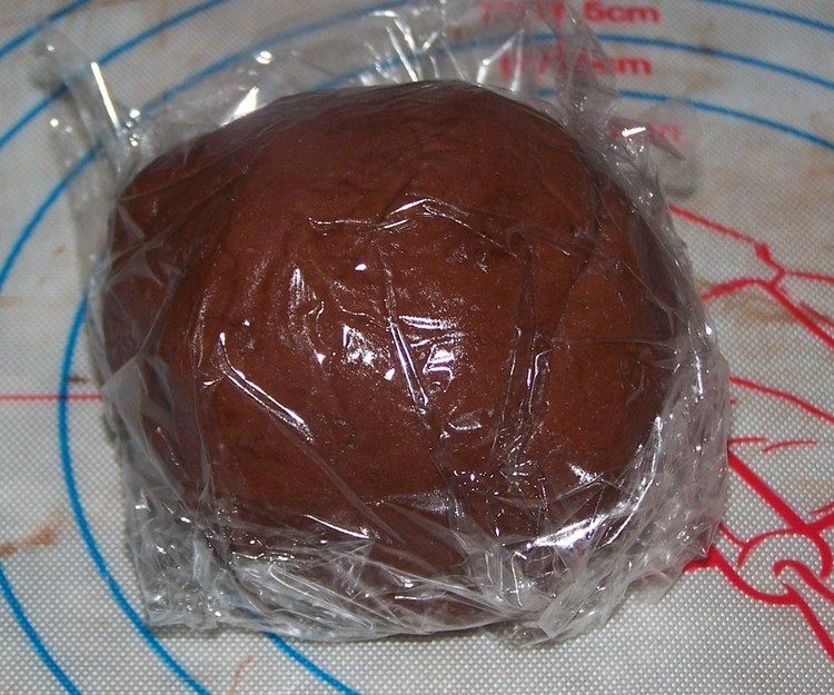 棋格饼干,加入过筛后的粉类,用刮刀切拌均匀即为原味面团。包上保鲜膜放在一旁待用(如果是天热的话,就放入冰箱冷藏至少1小时);同样方法做好可可味面团;