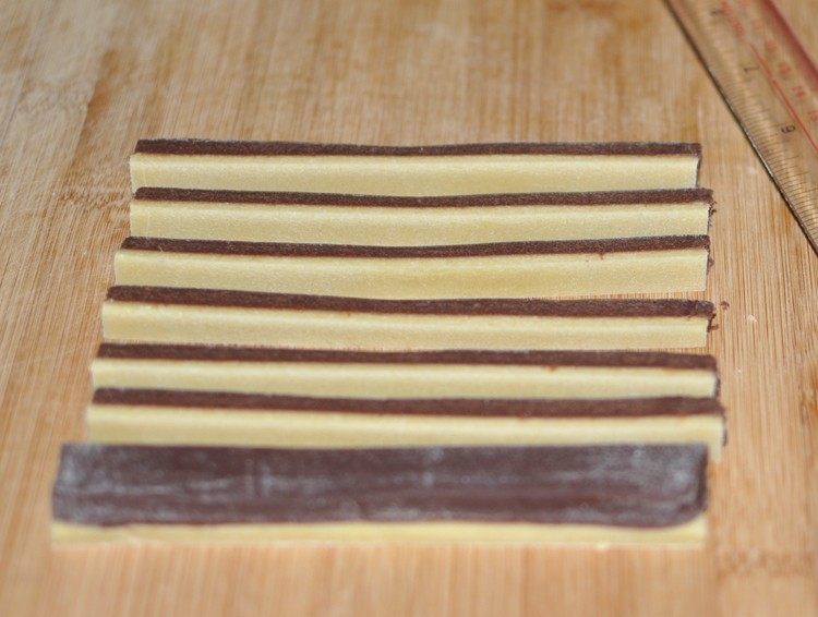 棋格饼干,将2种面团尽量整形成大小、厚度一样,将原味面团刷上<a style='color:red;display:inline-block;' href='/shicai/ 17'>蛋清</a>后放在可可面团上,再切成大小一样的长条;