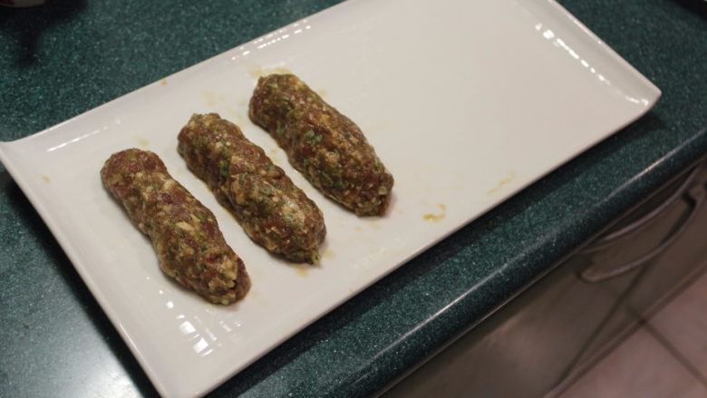 串烧羊肉卷(巴基斯坦风),将竹签取出。重复相同的步骤将所有羊肉泥塑型成长型肉串。