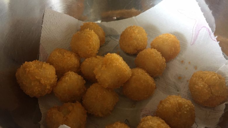 让你欲罢不能的欢乐土豆球,放入铺好厨房纸的盆中,吸取多余的油分;