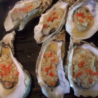 蒜蓉烤生蚝,并撒上几粒红辣椒装饰,不喜欢的话完全可以不放红辣椒,再放进烤箱烤7-8分钟,即可