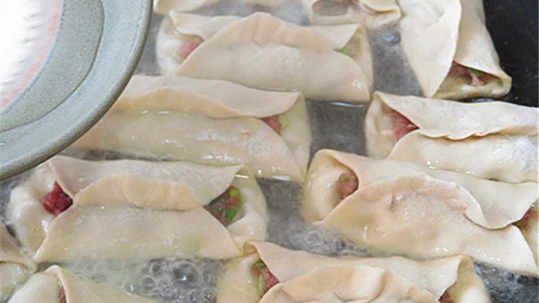 羊肉煎饺,用5克面粉加12克水调成面糊水,均匀浇在锅贴上,不会调面糊水的也可以直接用半碗水浇在锅贴上