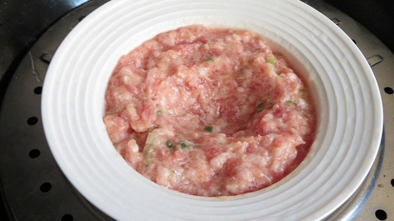 肉饼蒸蛋,调匀好以后,用勺子压个坑,锅内放水,肉末上锅蒸5分钟