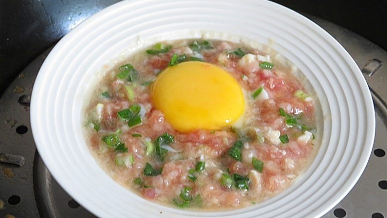 肉饼蒸蛋,5分钟后磕入一个鸡蛋,周围洒上葱花,盖上盖子再蒸10分钟左右
