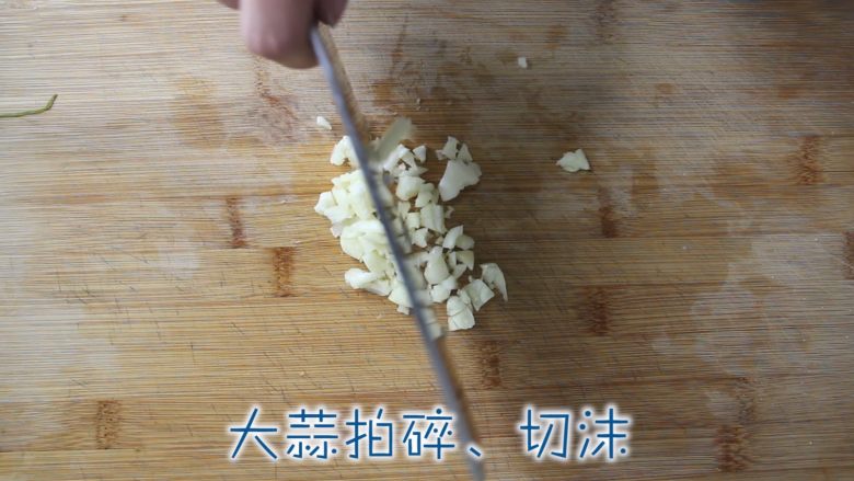 凉拌菠菜花生米,大蒜拍一下、剁成末。