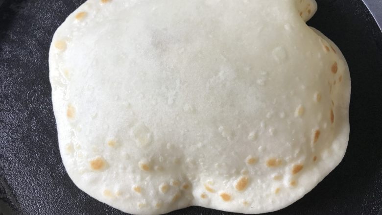 鸡蛋灌饼香肠卷,再翻面烙一会,来回的翻两次,饼就会慢慢鼓起来