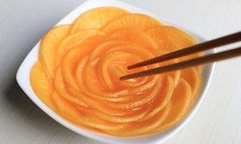 橙香萝卜花,将萝卜片取出,在一个略有高度的盘中依次码放,大片放边上,越往里越小,中间卷起,即成玫瑰花样,浇少许果汁即可。