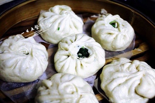 绿油油的菜包子,将包好的包子放入垫了油纸或布的蒸笼里。在锅子倒入适量热水,放上蒸笼,盖上盖子,第二次发酵10-15分钟。