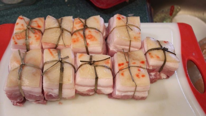 东坡肉,将五花肉用将用传统的閵草绳十字交叉绑好,以防熬软烂后肉块破裂。