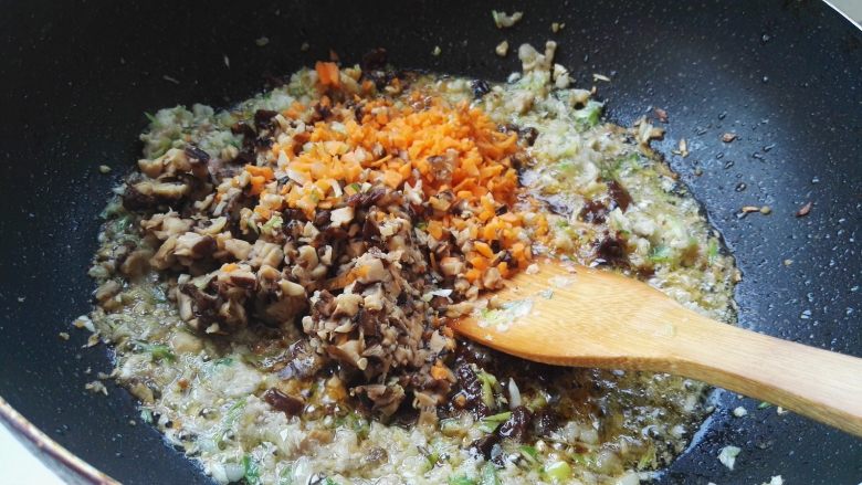 百变面食之家常生煎包,放入香菇碎、胡萝卜碎翻炒。