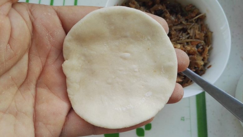 百变面食之家常生煎包,取一个面剂,擀成一圈薄中间厚的面片(我包包子不擀皮,都是两手手指转圈捏的,当然是一圈薄,中间厚)。
