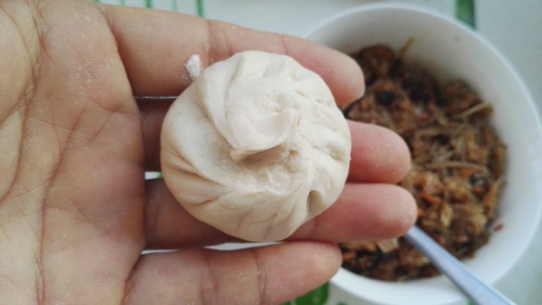 百变面食之家常生煎包,两手协调依次捏褶,封口包严(不会了可以百度包包子视频,能包一块不漏馅就可以了,想包出漂亮的包子需要多练,我包的包子属于包子好吃不在褶上)。