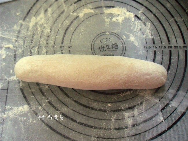 芝麻紫薯馅煎饼,案板上撒些干面粉,将面团揉成长条