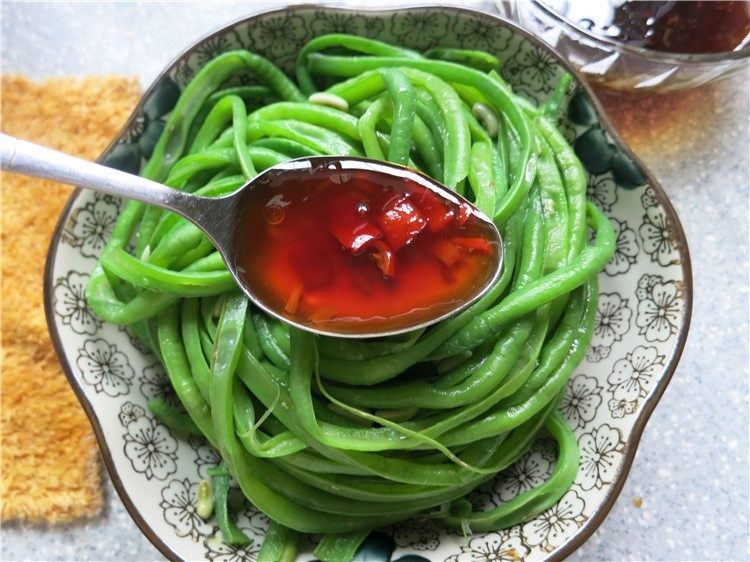 吃豇豆还用麻汁?快来试试这个--手撕豇豆,撕好的豇豆条放在盘子里,将汤汁浇在上面