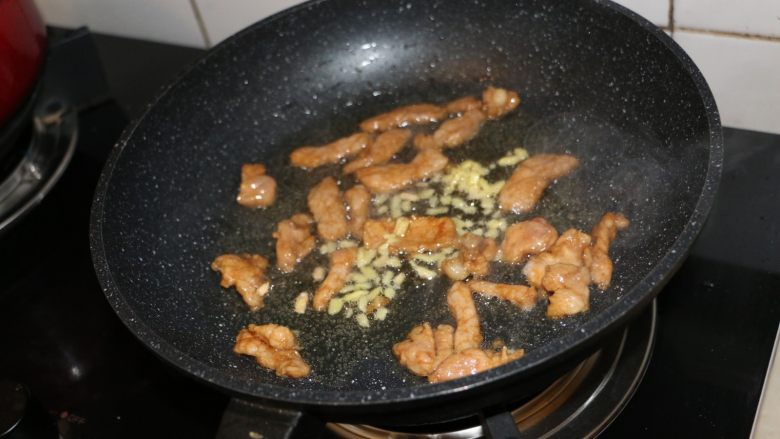 蒜薹小炒,肉片变色后,放入姜末,继续翻炒。