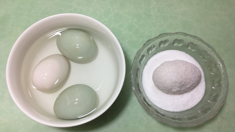 在家也能腌出流油的咸鸭蛋,然后将浸泡好的鸭蛋放入盐碗中,表面都沾满盐。