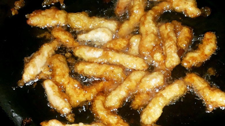 糖醋里脊,然后放入油锅炸,如果是炒锅那油就多放一些了,炸到表面生粉变色,然后捞出来,再炸一次,到表面有点焦变脆后,把油晾掉让肉干一点